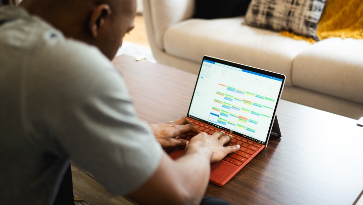 A Man Typing on a Microsoft Surface Tablet