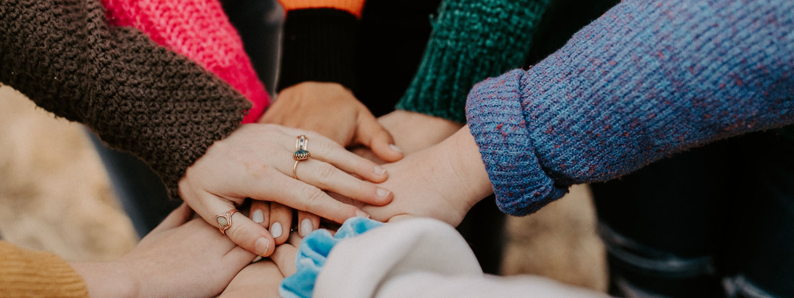 A group of people putting their hands together in a circle