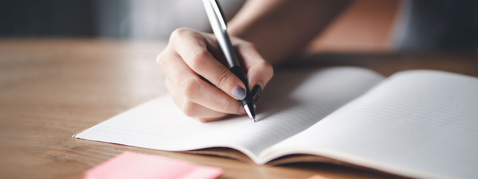 Business woman holding pen and papers making notes in documents on the table.