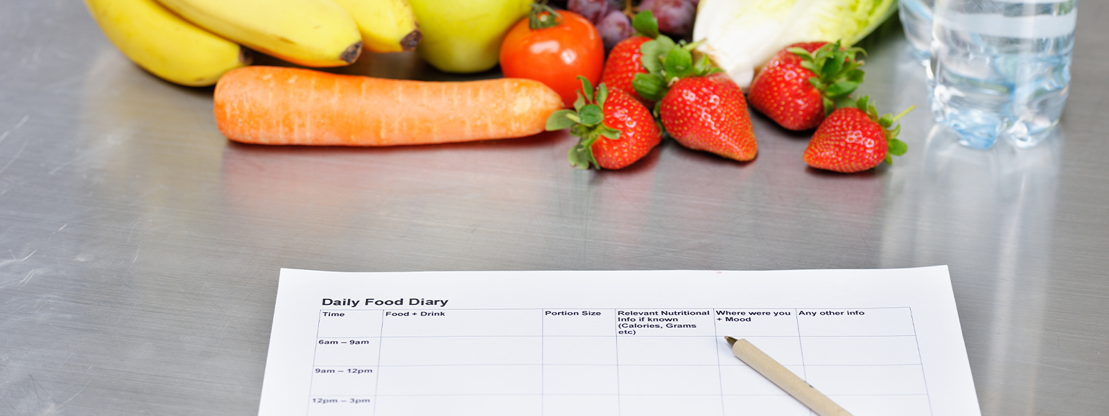 A daily food diary and some healthy eating options with fruits and vegetables.