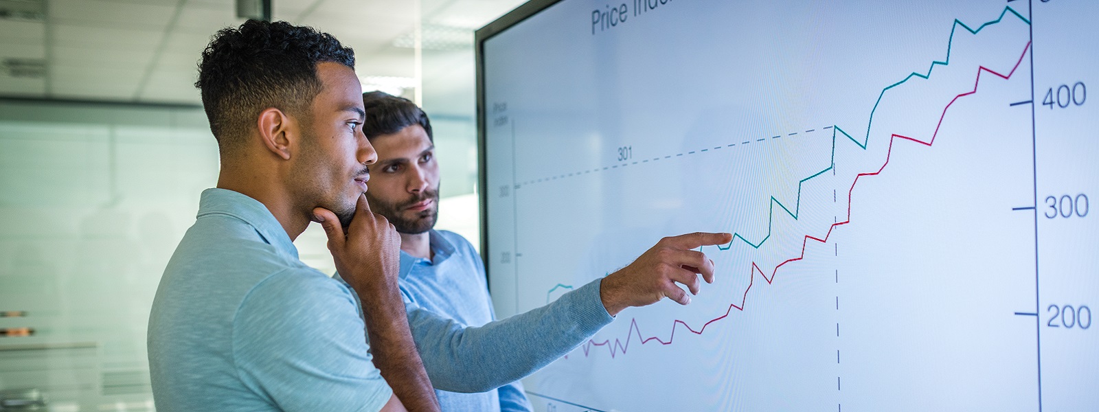 A man explaining line graph to his coworker.