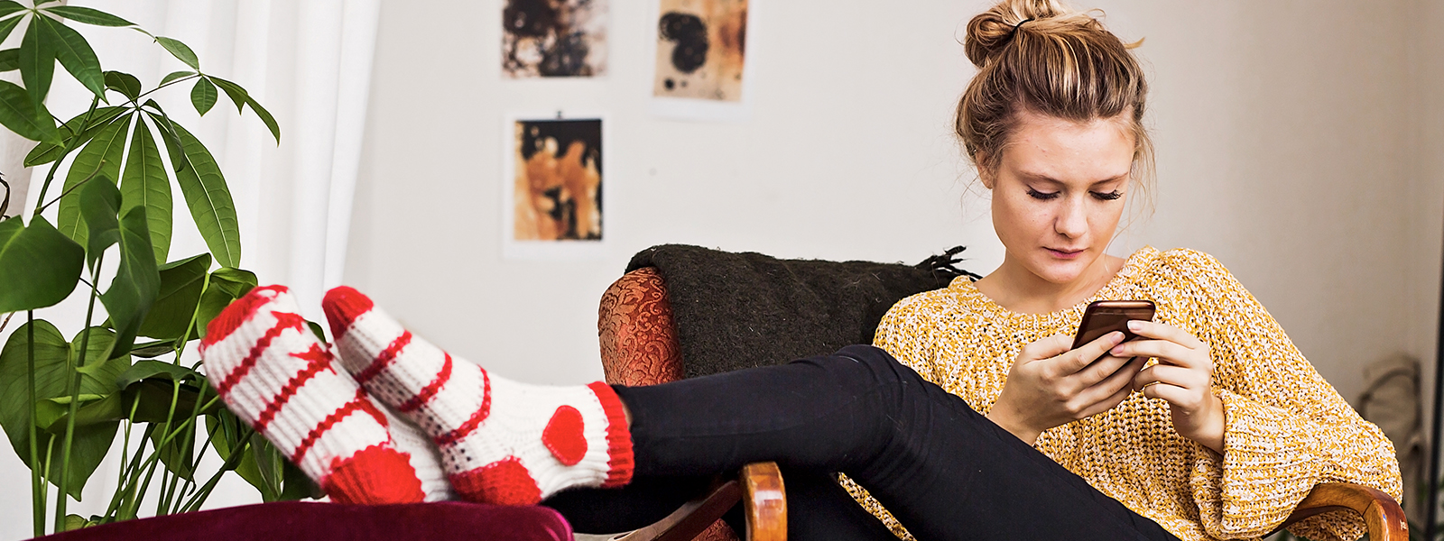 a girl sitting on a couch using her phone.