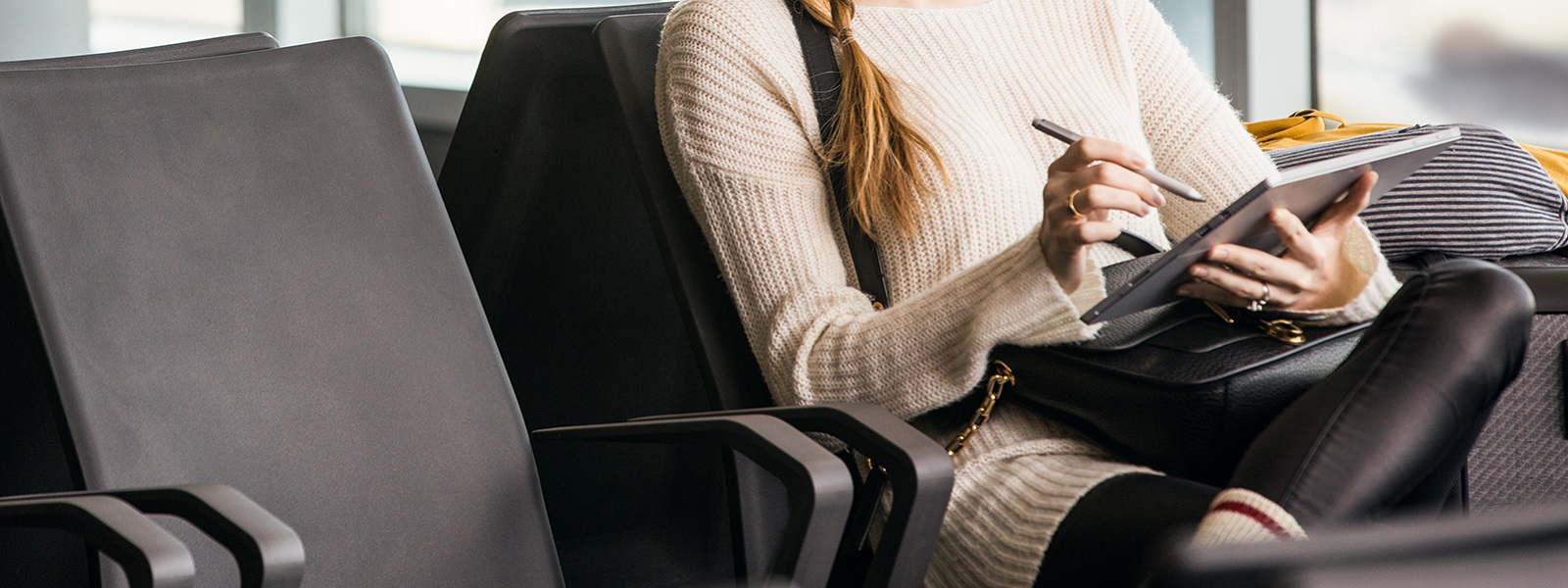 Enterprise young female achieving in airport during business travel and mobility. Including Surface Pen.