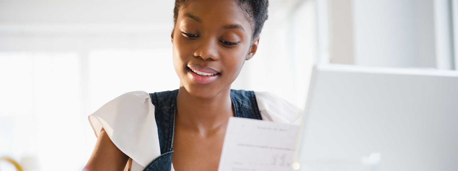 A young woman paying her college bills online.