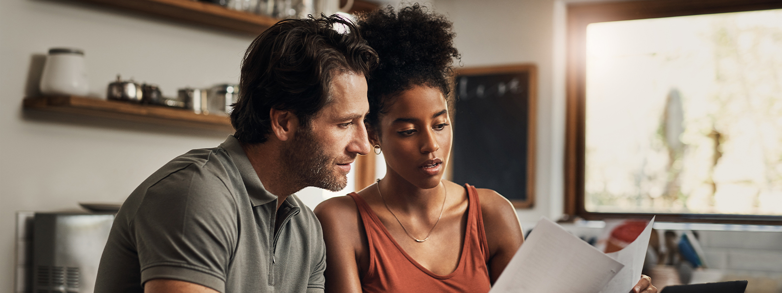 An young couple going through paperwork while doing their budget at home.