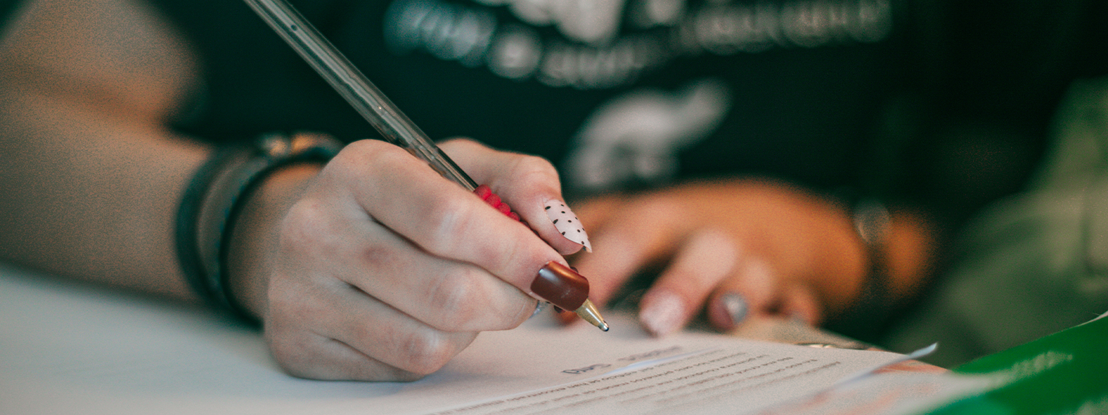 A woman hand writing in a notebook.