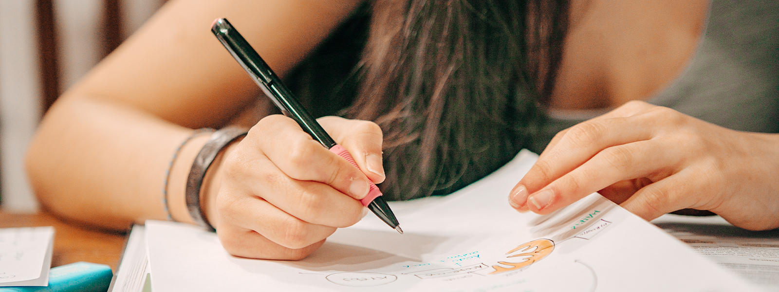 A woman writing some notes in a notebook.