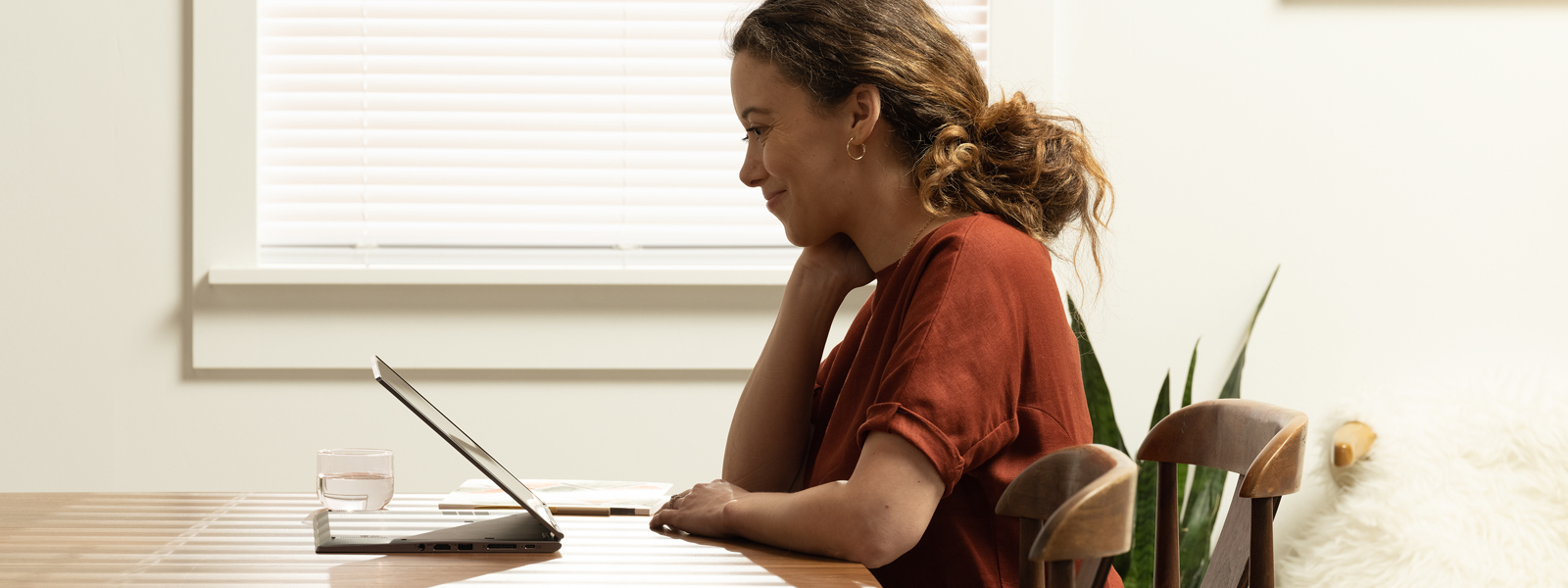 a woman working on dining room table with a Lenovo ThinkPad X1