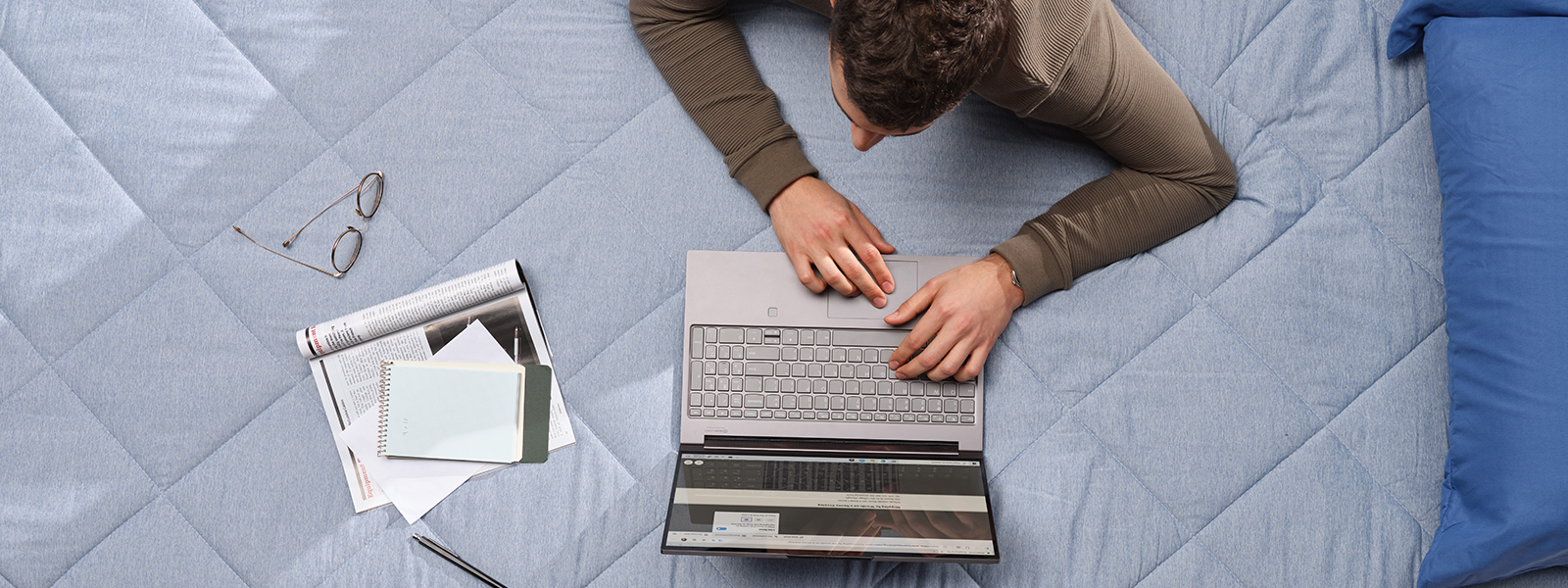 a man working on his bed on a laptop. 