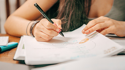 a woman writing some notes in a notebook