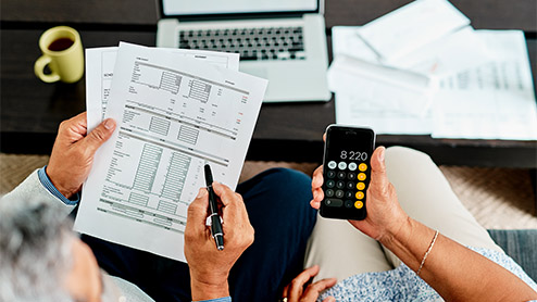 a couple calculating their finances together at home and balancing their numbers