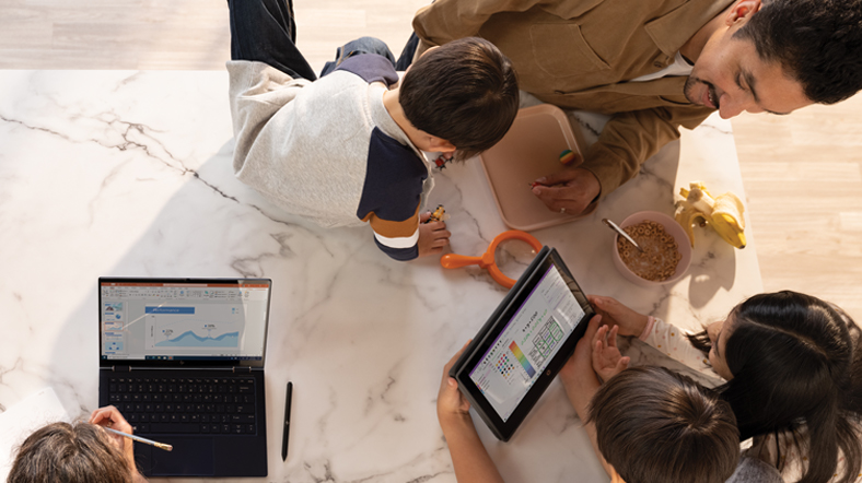 A family working and learning remotely around their kitchen table. The mother has a PowerPoint file open on an HP Elite Dragonfly. The father and two older children are looking at OneNote Math Assistant on an HP Probook x360.