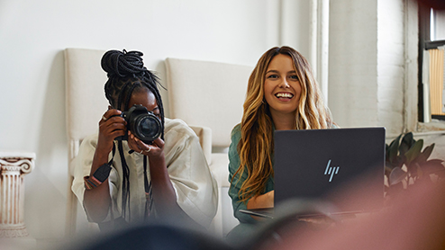 Two students working on a budget while testing their camera and laptop