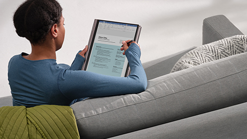 Woman using a digital pen inking to review a resume Word document using HP Spectre X360