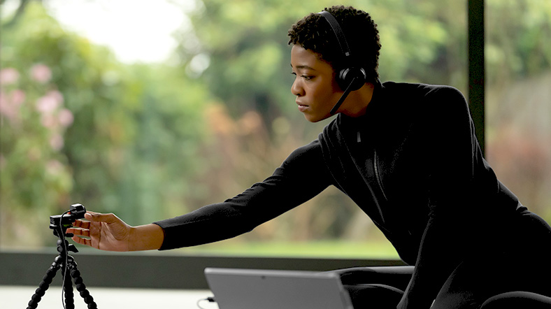 a person wearing a headset setting up a webcam