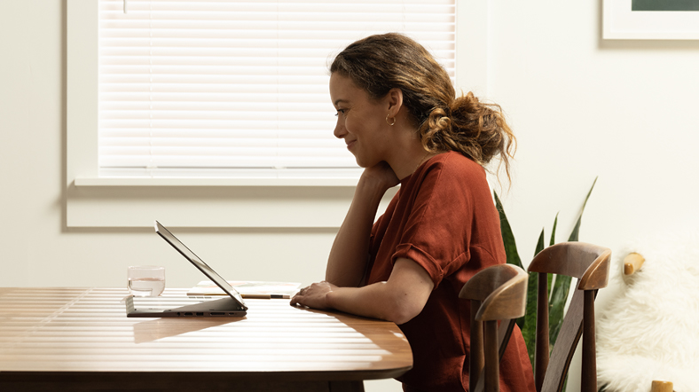 a woman working on dining room table with a Lenovo ThinkPad X1