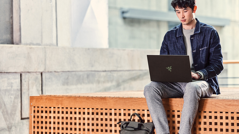 Male student outside on the go working on RazorBlade.