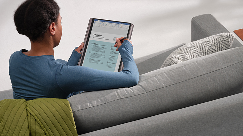 Woman using a digital pen inking to review a resume Word document using HP Spectre X360